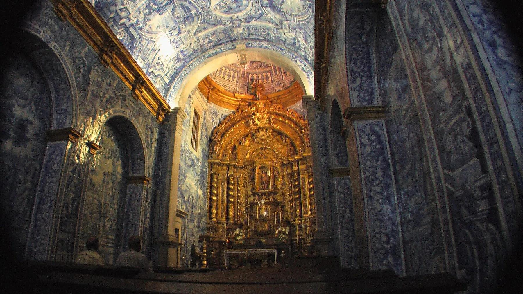 Kirkerommet i São Lourenço i Almancil med vegger dekket av blå azulejos og forgylt alter i koret