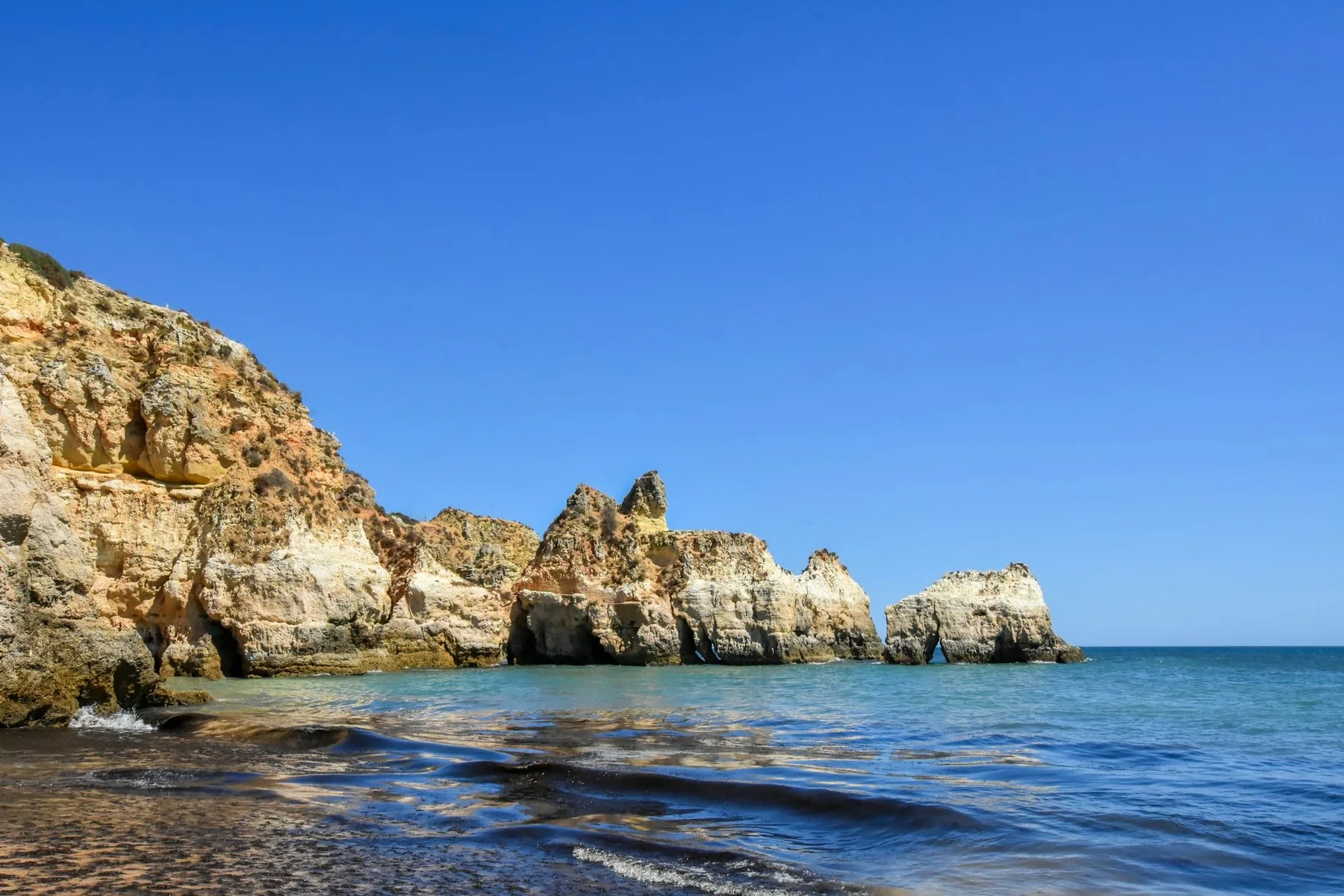 Gule sandsteinsklipper ved Praia dos Três Irmãos utenfor Alvor med havet nedenfor