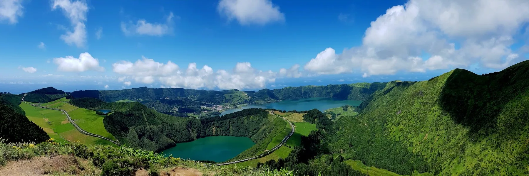 Panorama over en kratersjø omkranset av grønne vulkanrygger på São Miguel, Azorene