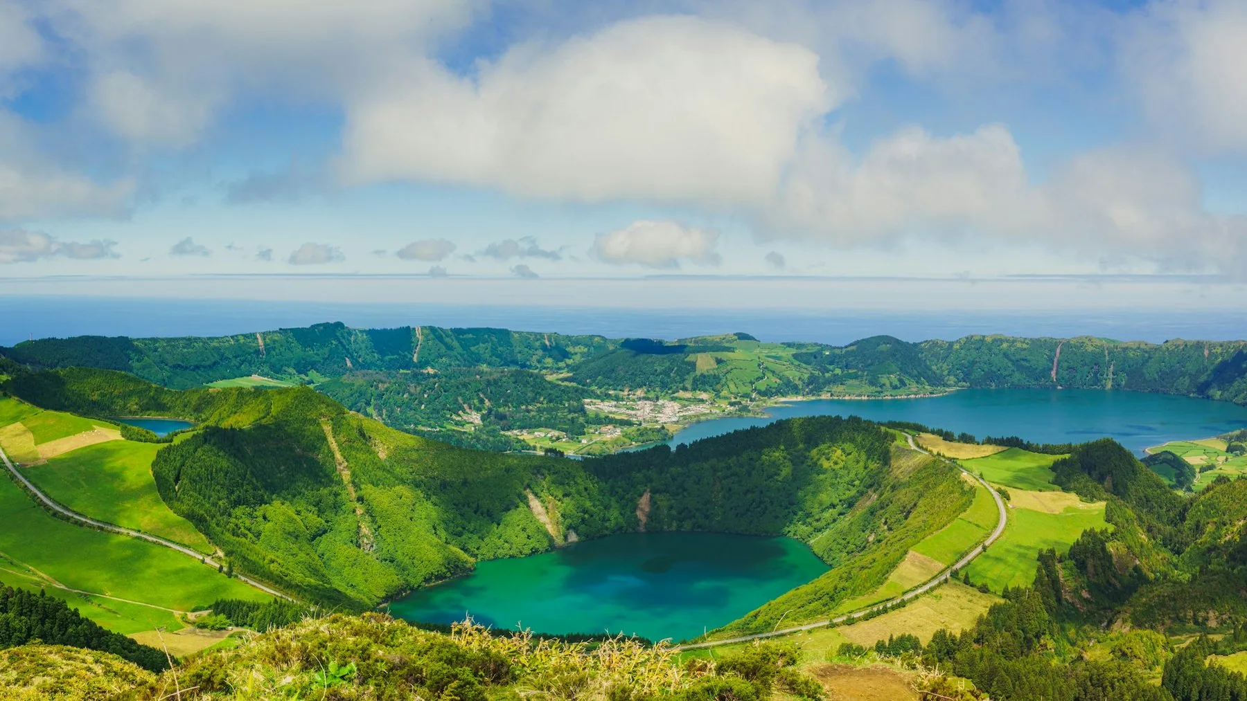 Grønne kratersjøer omkranset av bratte åser med det blå Atlanterhavet bak på São Miguel