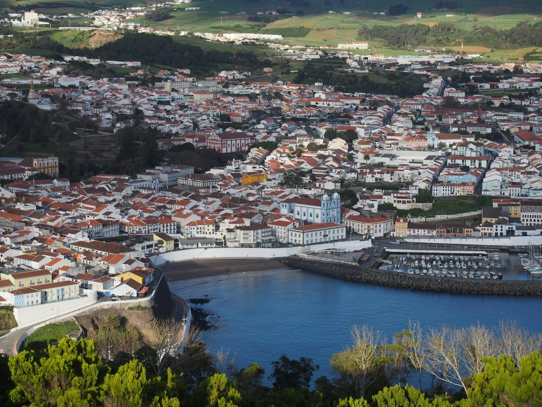 Angra do Heroísmo sett ovenfra, med byen langs bukta og havet bak, Terceira