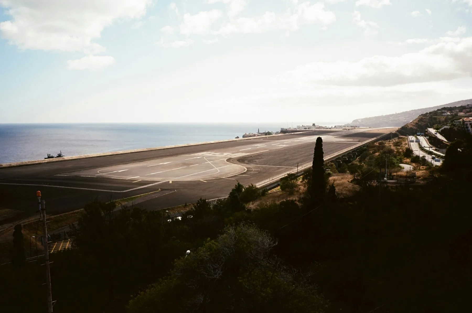 Rullebanen på Madeira lufthavn ligger langs kysten med Atlanterhavet og bratte åser i bakgrunnen