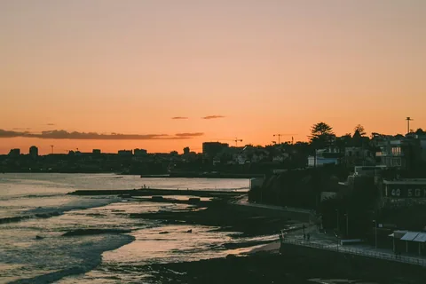 Silhuetten av bygningene langs stranden i Estoril i solnedgang