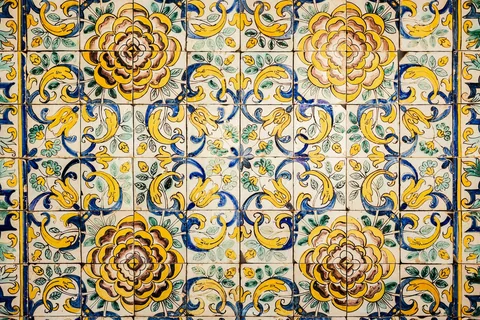 Nærbilde av gamle azulejos i Lisboa med gule, blå og brune blomstermotiv