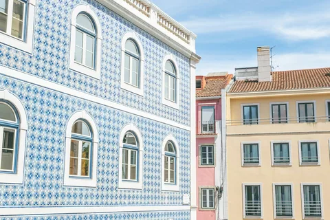Bygård i Lisboa med fasaden dekket av blå og hvite azulejos, ved siden av gule og rosa nabohus