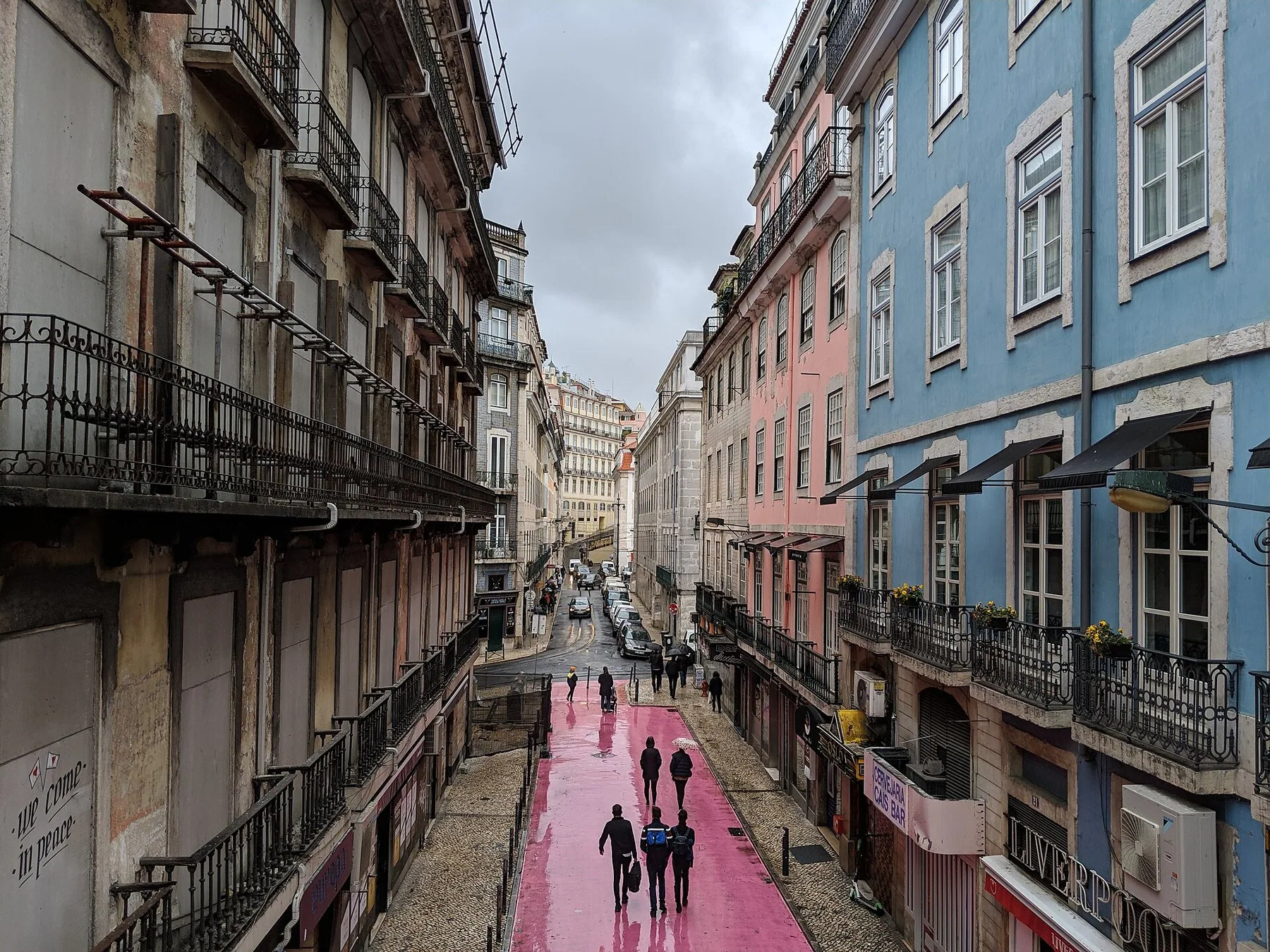 Den rosamalte gata Rua Nova do Carvalho sett ovenfra, mellom høye bygårder med smijernsbalkonger