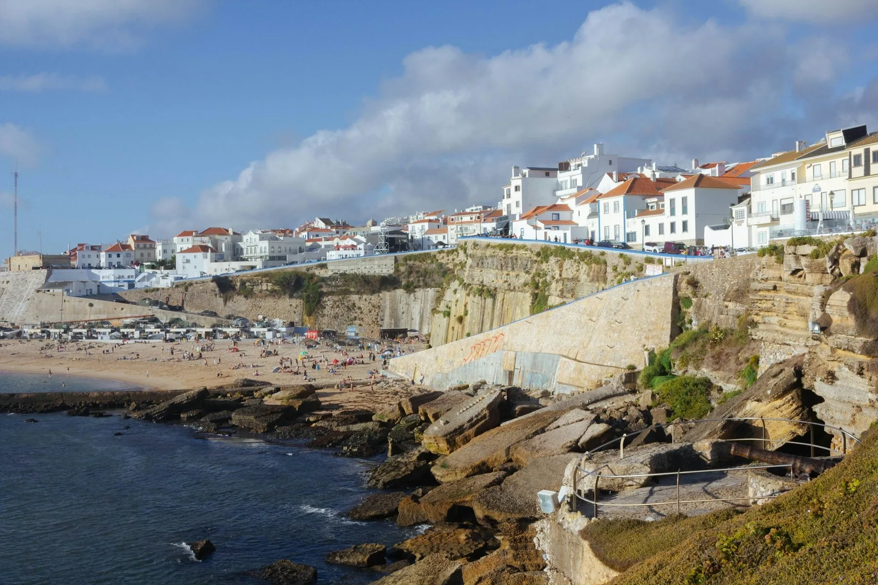 Stranden og klippene i Ericeira med de hvite husene i byen oppe på kanten