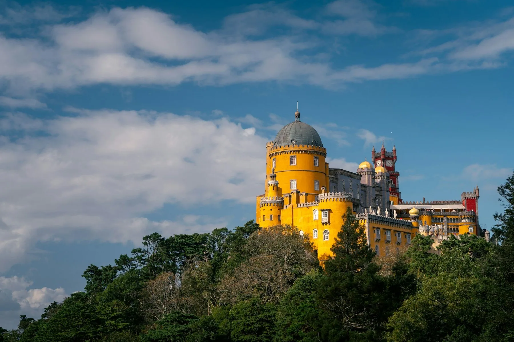 Det gule og røde Pena-palasset på toppen av den skogkledde åsen i Sintra