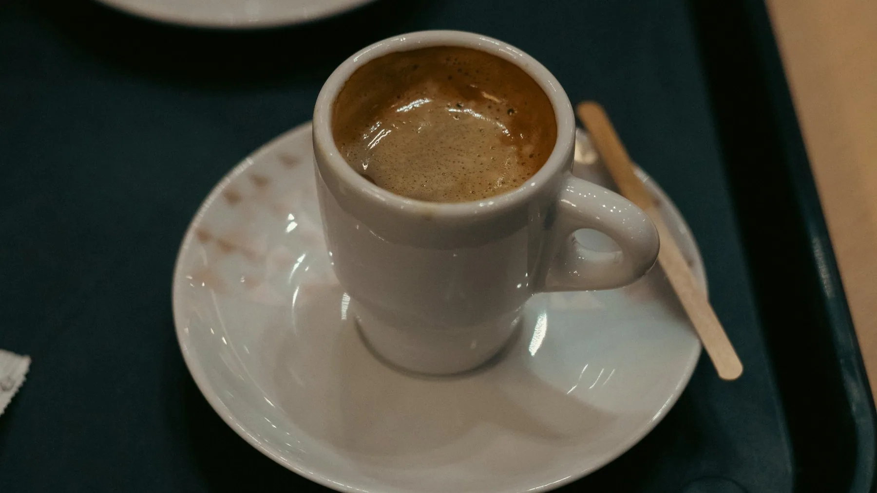 En liten espresso, en bica, i hvit kopp på skål på en kafe i Lisboa