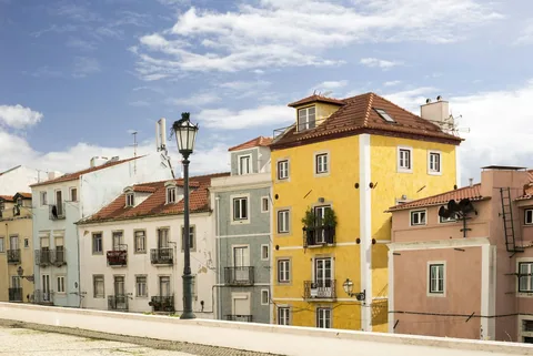 Renoverte bygårder i ulike farger i en gate ved Panteao Nacional i Lisboa