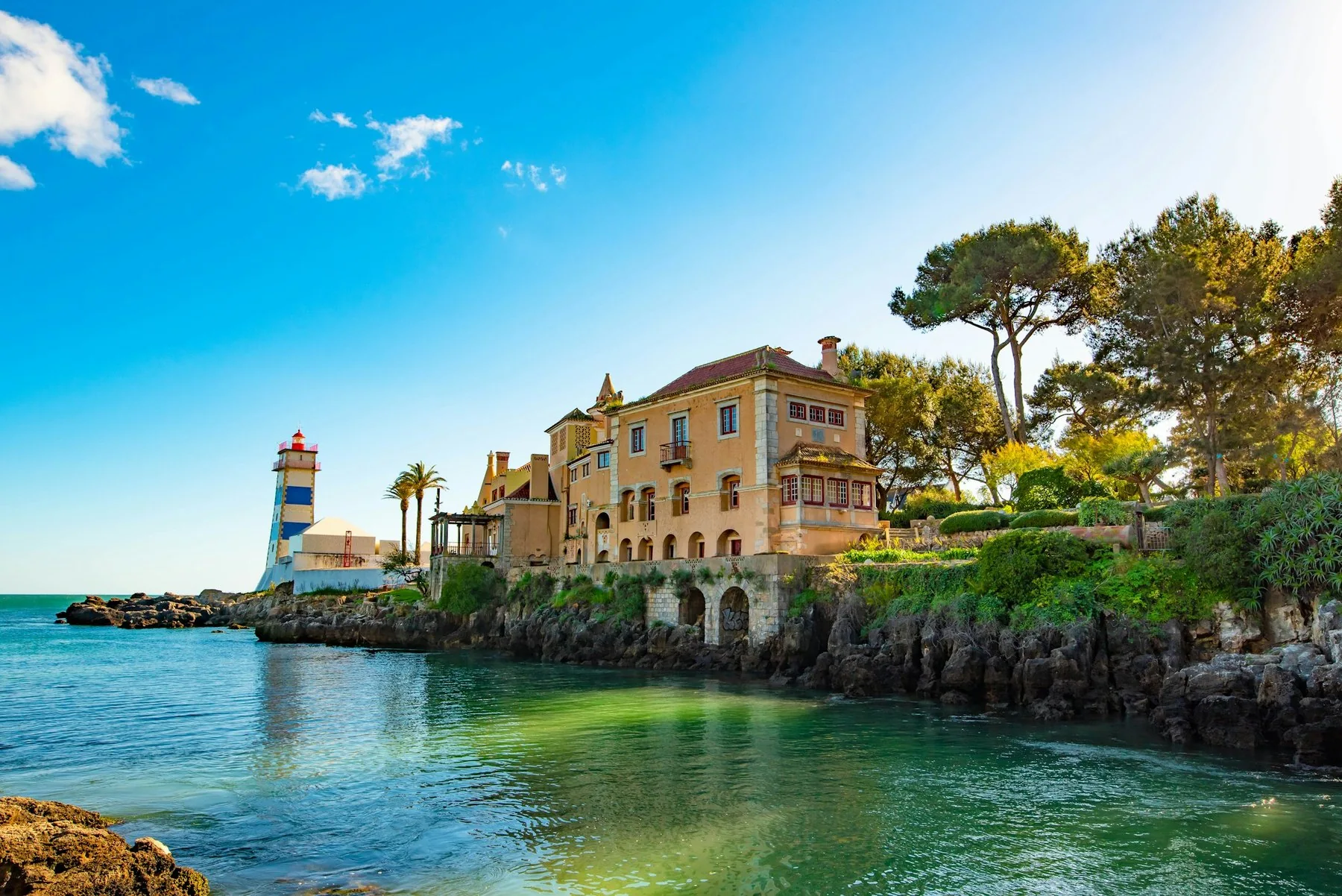 Gammel steinbygning ved sjøkanten i Cascais under klar blå himmel