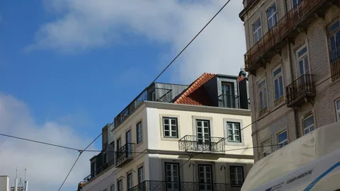 Leilighetsbygg med balkonger og takterrasse i bydelen Graca i Lisboa under blå himmel