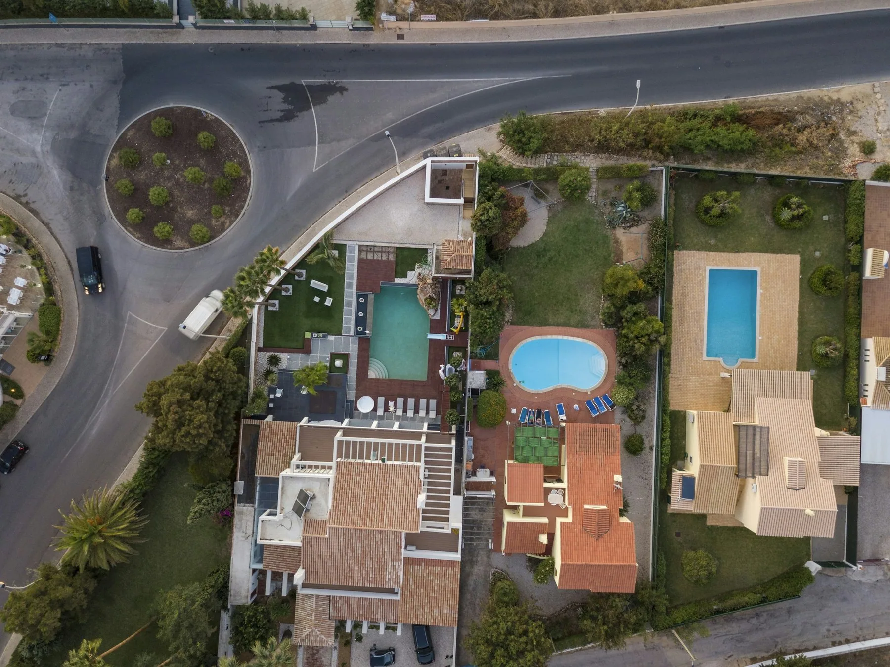 Feriehus med teglsteinstak og private svømmebassenger sett ovenfra i et boligområde ved Guia i Algarve