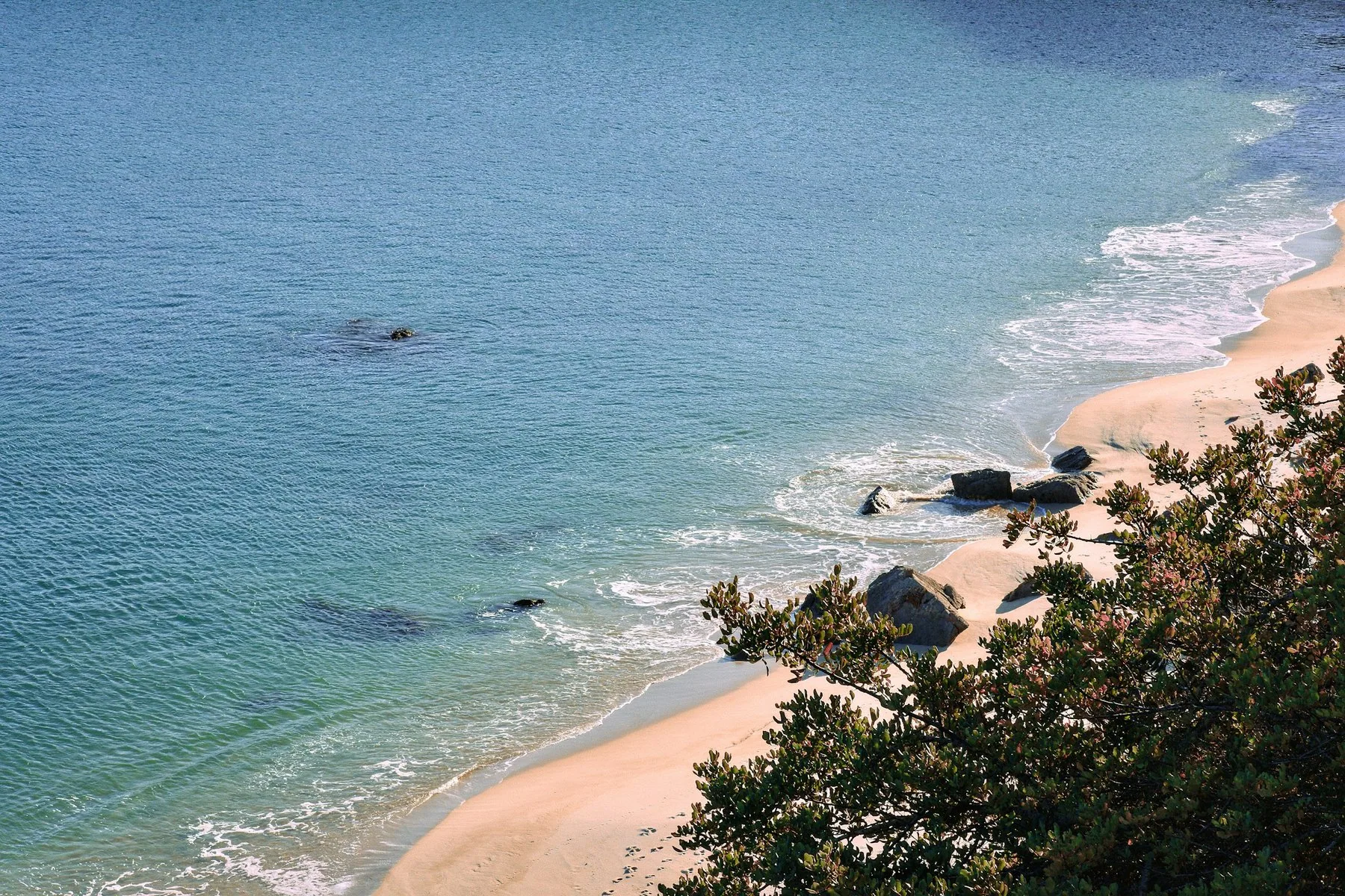 Praia dos Galapos ved Arrabida med en båt på det rolige, klare vannet