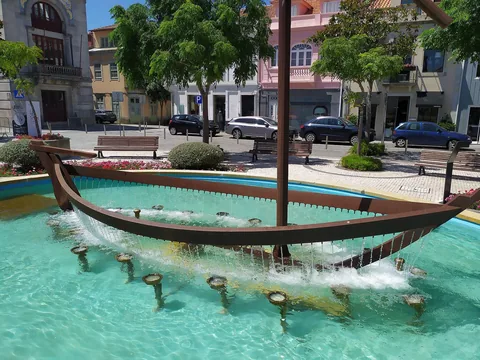 Fontene formet som en tradisjonell fiskebåt i et turkis basseng på et torg i Esposende