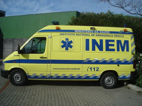 Gul INEM-ambulanse fra det portugisiske helsedepartementet parkert utenfor en bygning