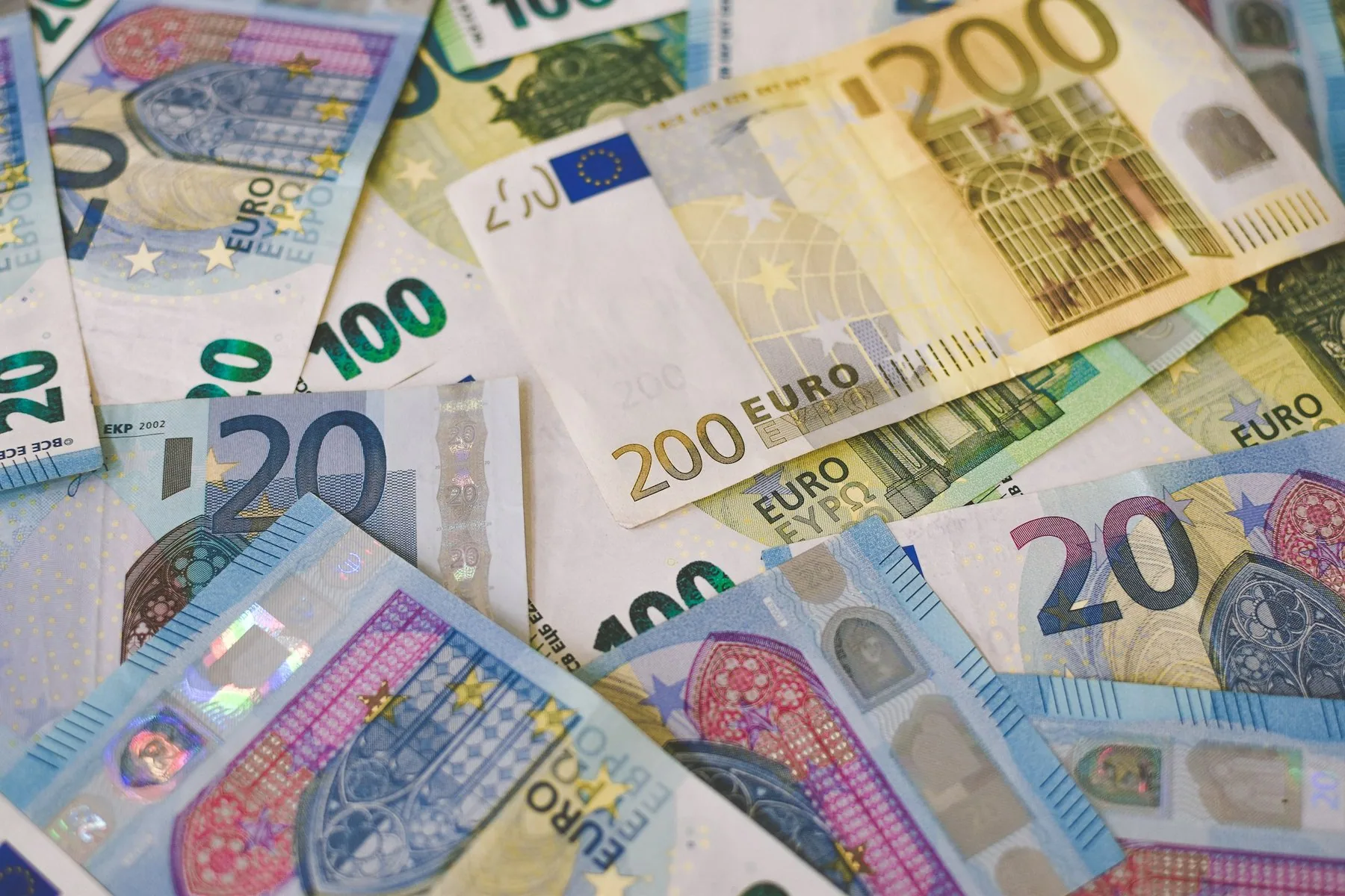 Spredte eurosedler i ulike valorer, tjue, hundre og to hundre euro, sett ovenfra