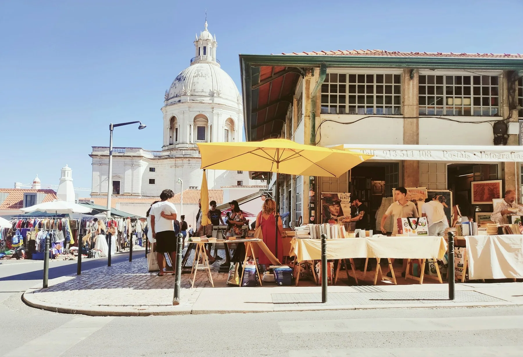 Markedsboder med gul parasoll foran den hvite kuppelen på Panteão Nacional i Lisboa