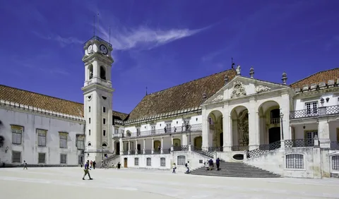 Universitetsbygningen med det høye klokketårnet i Coimbra under blå himmel