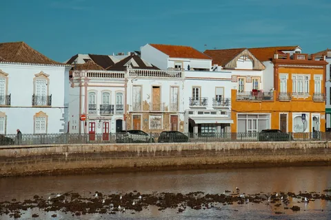 Hvite hus og kirketårn langs Gilao-elven i Tavira i Algarve