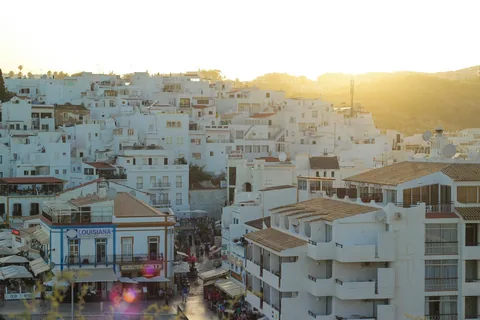 Hvite hus og leilighetsbygg tett i tett i sentrum av Albufeira i lavt kveldssollys