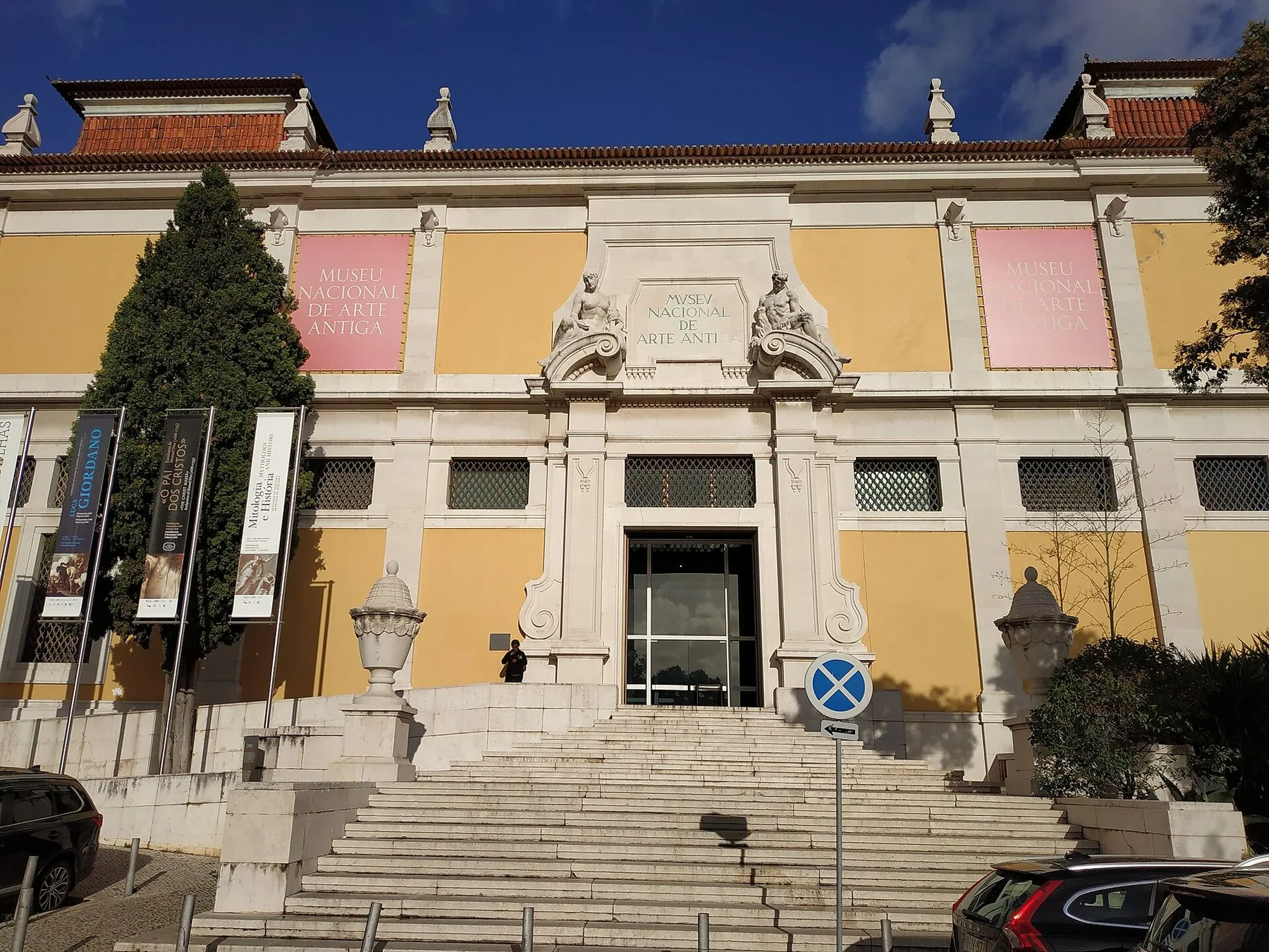 Den gule barokkfasaden til Museu Nacional de Arte Antiga i Lisboa med brede steintrapper og hvite portaler
