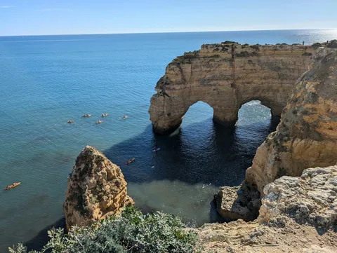 Klippebuer i gul kalkstein møter havet ved Benagil i Algarve en solskinnsdag