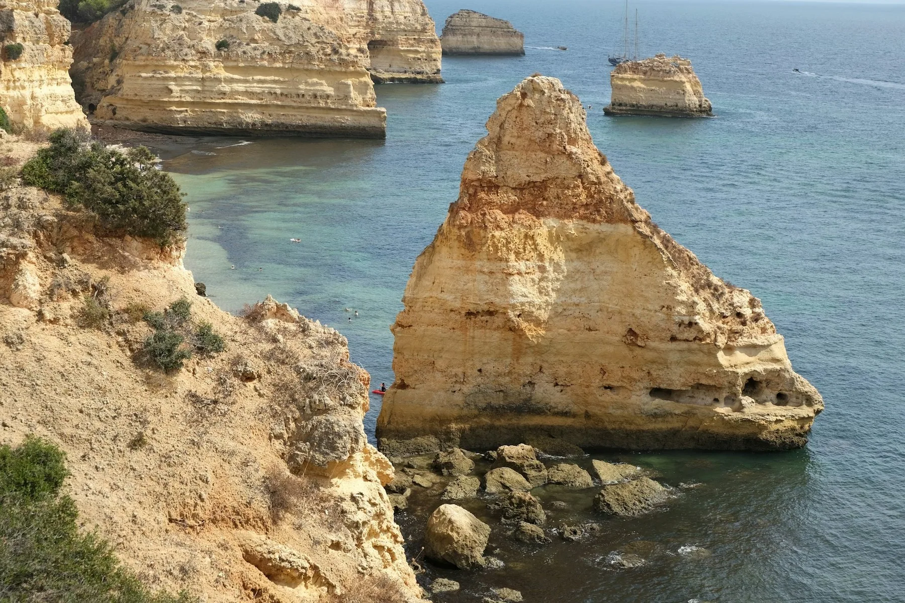 Gule kalksteinsklipper og en frittstående klippe i sjøen ved Praia da Marinha i Algarve