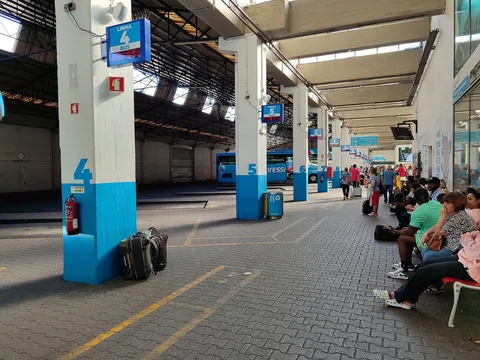 Reisende med bagasje venter ved perrongene på bussterminalen Sete Rios i Lisboa