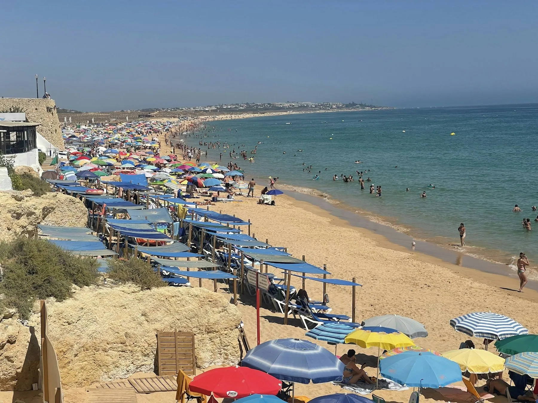Stranden i Armacao de Pera i Algarve fullpakket med parasoller og badegjester i hoysesongen