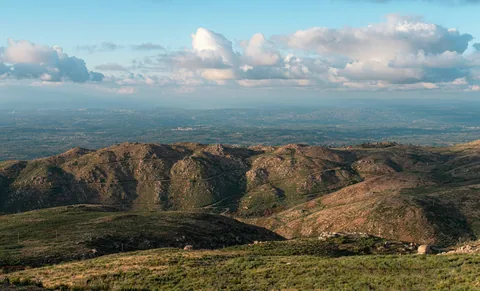 Grønne og brune fjellrygger i Serra da Estrela under klar blå himmel