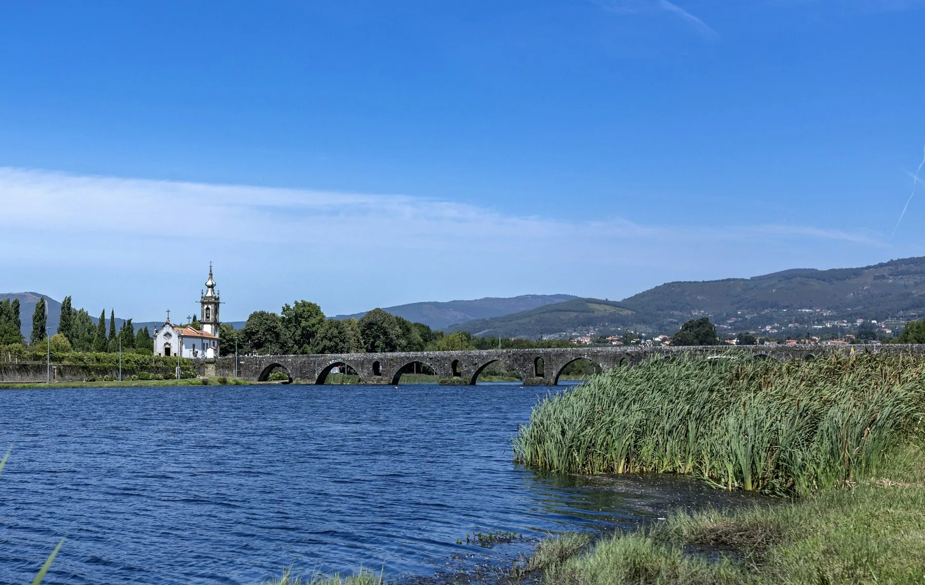 Den gamle steinbroen over Lima-elven i Ponte de Lima, med kirken Santo António på motsatt bredd