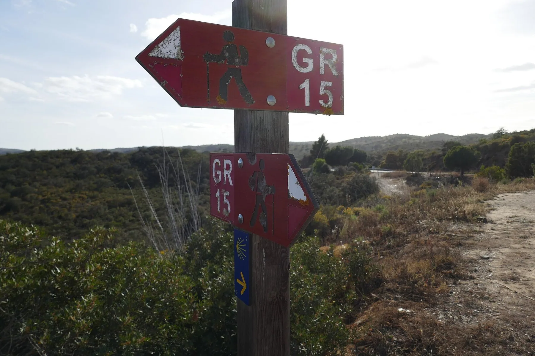Veiviserpil i tre med rødt og hvitt GR15-merke for Grande Rota do Guadiana ved en sti i kratt ved Alcoutim