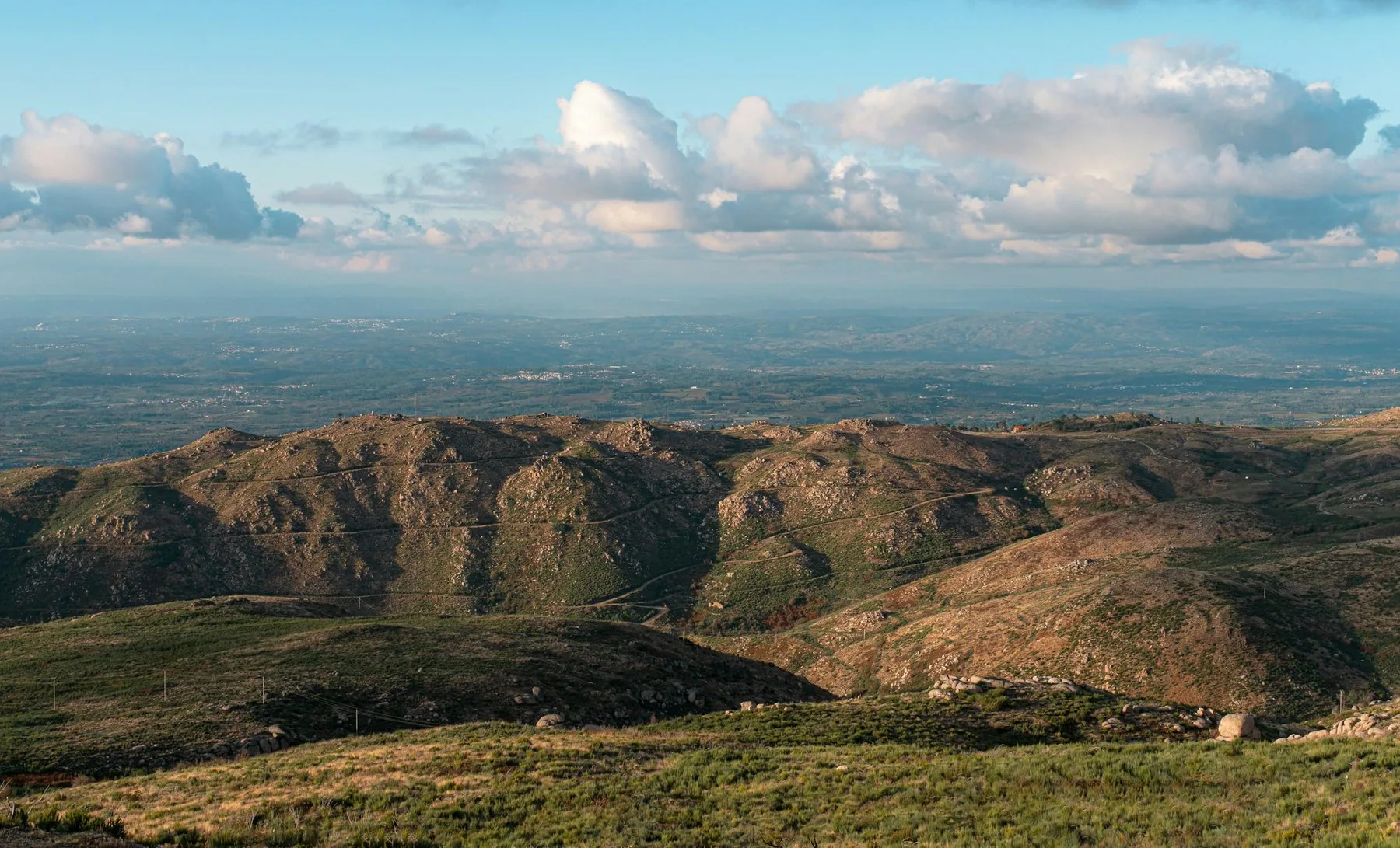 Grønne og brune fjellrygger i Serra da Estrela under klar blå himmel